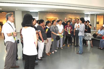 美术馆志愿者在展厅内为现场观众讲解陈源初的油画作品。